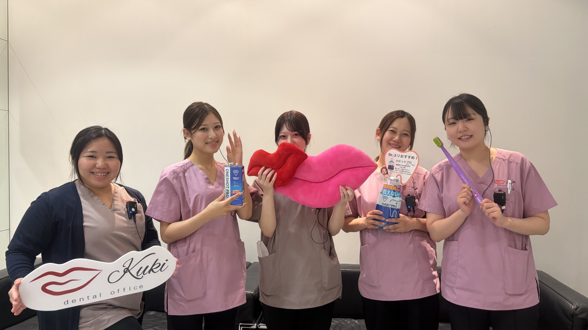 ロゴと小物を手にご応募をお待ちしているスタッフ
